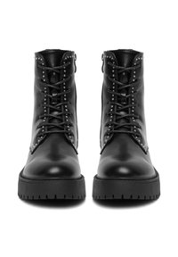 Botas de cuero negras hasta el tobillo con punta redondeada, parte delantera con cordones y tachuelas decorativas plateadas a lo largo de los bordes. Suela de goma gruesa con relieve.