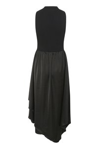 Robe noire avec un haut en tricot ajusté et une jupe en satin fluide et superposée avec un ourlet meurtrier. Texture lisse tout au long.