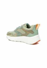 Zapatilla verde con parte superior de malla texturizada, acentos suaves, entresuela blanca y tirador en el talón de color naranja. Presenta cordones delgados para un ajuste seguro.