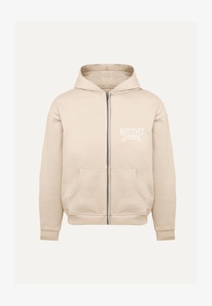 Beige zip-up hoodie lavet af blødt stof, med en hætte med snøre, forlommer og et lille hvidt logo på venstre brystområde.