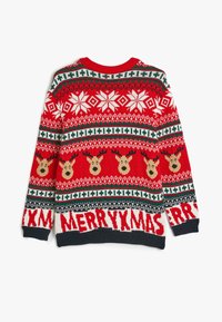 Röd stickad tröja med renmotiv, snöflingor och texten "GOD JUL" i vitt. Accentuerad med gröna och svarta mönster.