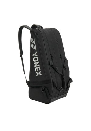 Sac à dos de sport noir Yonex avec plusieurs compartiments zippés et bretelles réglables, conçu pour le rangement et le transport de raquettes.