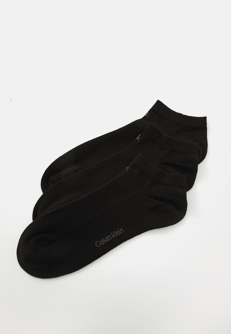 Três pares de meias de algodão pretas até ao tornozelo com uma textura suave e um discreto logo da Calvin Klein perto do dedo do pé. Design simples e padrão.