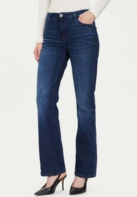 Jeans in denim blu scuro con vestibilità classica a gamba dritta, tasche frontali, chiusura con bottoni e dettagli di scoloritura discreti lungo le gambe.