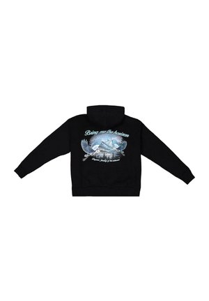 Fekete kapucnis pulóver grafikás nyomattal, amelyen repülő madarak és kék hegyek láthatók, a felirattal: "Hozd el nekem a horizontot".