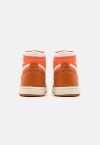 Höga sneakers i orange och brunt läder, med vita accenter, vadderad krage och texturerad gummisula, som visar en stilren design.