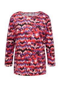 Long-sleeve top in a wavy pattern of red, purple, and black on a lightweight fabric with a boat neck and relaxed fit.
