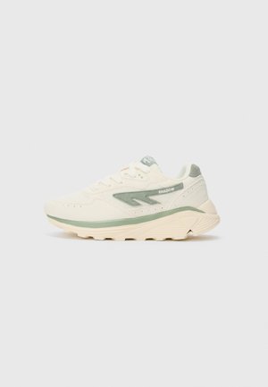 Beige und hellgrüne Sport Sneakers mit dicker Sohle, Obermaterial aus Mesh und Wildleder sowie "SHADOW"-Text auf der Seitenblende.