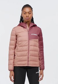 Giacca a vento rosa e bordeaux con cappuccio, chiusura con zip, motivo trapuntato orizzontale e logo TERREX sul petto. Polsini elasticizzati.