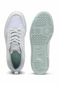 White athletic shoes with a smooth leather upper, mint green accents, and a textured rubber sole featuring a geometric pattern.
