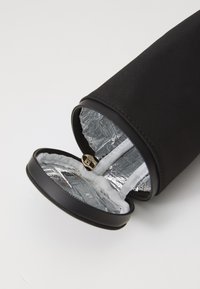 Sac rond noir isolé avec fermeture éclair, doté d'une doublure intérieure argentée et d'un matériau extérieur noir lisse.