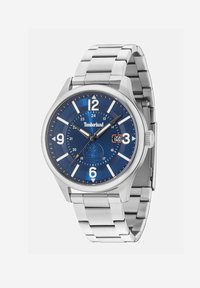 Montre en acier inoxydable argenté avec un cadran bleu, grands chiffres blancs, affichage de la date à 3 heures et un bracelet métallique.