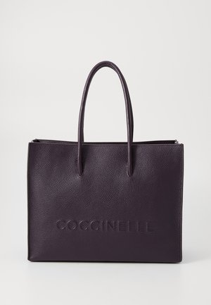 Purple leather tote bag with two long handles, embossed logo on the front, and a textured surface. Closed top with a zipper.