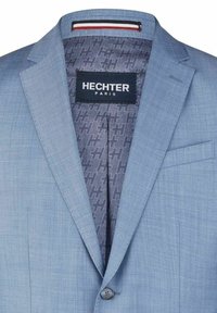 Hellblaues Blazer mit glatter Textur. Verfügt über ein grau gemustertes Futter und ein Etikett "Hechter Paris". Ein-Knopf-Verschluss und Klappentasche.