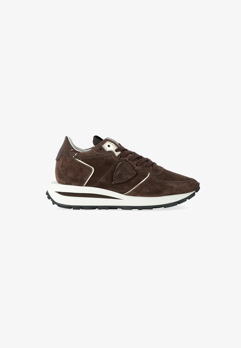Sneaker in suede marrone con lacci marroni scuri, accenti crema, una suola intermedia bianca e una suola esterna in gomma nera, mostrato di lato su uno sfondo bianco.