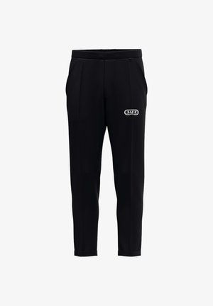 Zwarte taps toelopende broek met zijzakken en een klein wit JAKO Sport-logo op de rechterdij, met een aansluitende tailleband en omslagzomen.
