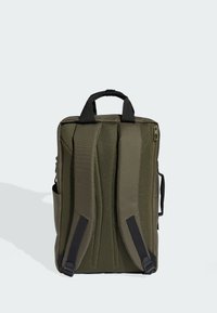 Olijfgroene rugzak met een mesh achterpaneel, gevoerde banden en een handvat bovenaan. Voorzien van zijvakken en een hoofdvak met ritssluiting.