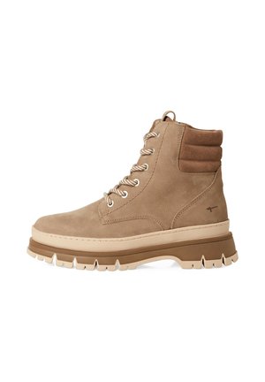 Beige Wildleder-Stiefeletten mit einer robusten Gummisohle, ausgestattet mit einem gepolsterten Kragen, Metallösen und strukturierten Schnürsenkeln. Glatte und robuste Oberflächenstruktur.
