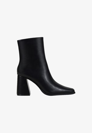 Bota de cuero negro hasta el tobillo con un diseño elegante, punta afilada y un tacón geométrico grueso. Textura suave sin hardware visible ni adornos.
