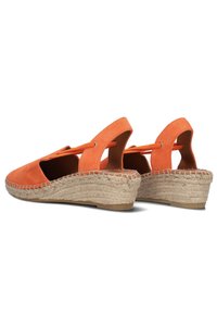 Oranje suede wedge espadrilles met open achterzijde, geweven jute middenzool en elastische banddetails. Glad oppervlak, afgeronde teenvorm.