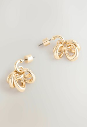 Kuldtooni metallist kõrvarõngad ringikujulises, omavahel pikendatud disainis. Omab siledat tekstuuri ja klamberkinnitust.