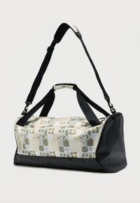 Τσάντα duffle με γεωμετρικό μοτίβο σε ύφασμα πράσινου, κίτρινου και λευκού, με μαύρο συνθετικό πάτο και ρυθμιζόμενο ιμάντα ώμου.