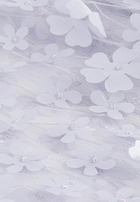 Helllila Spitzenstoff mit floralen Applikationen. Enthält verstreute Blumen aus weichem Material, akzentuiert mit kleinen Perlen in der Mitte.