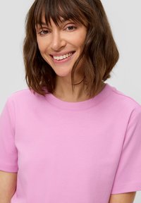 Lichtroze katoenen t-shirt met ronde hals en korte mouwen, met een gladde textuur en een simpel ontwerp. Geen patronen of accenten zichtbaar.