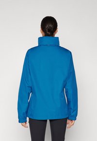 Veste bleue imperméable avec un col montant, des poignets élastiques et une coupe décontractée. Caractérisée par une texture lisse et un design minimaliste.