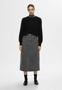 Mustra musternät, hallide teksased midi seelik esiseemega, põlvepikkune, koos mustade sokkide ja kingadega. Minimalistlik disain.