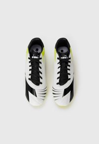 White and black soccer shoes with bright yellow accents, featuring a smooth texture, pointed design, and black shoelaces.