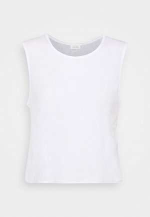 Haut court sans manches en coton blanc avec un col rond, présenté sur un fond clair uni.
