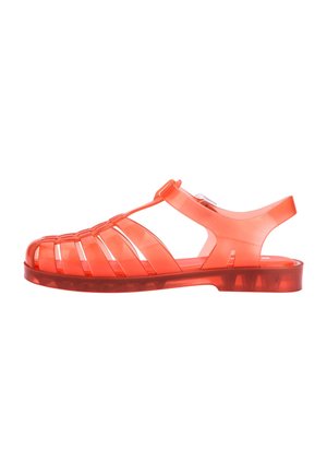 Przezroczyste czerwone sandały z gumy o paskowym designie, solidnej podeszwie i paskiem z tyłu zapewniającym pewne dopasowanie. Gładka faktura i lekkość.