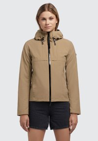 Giacca impermeabile khaki con cappuccio, zip frontale e coulisse elastiche. Presenta un design elegante e dettagli con logo discreto.