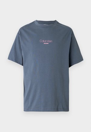 Graues Baumwoll-T-Shirt mit Rundhalsausschnitt und kurzen Ärmeln. Auf der Vorderseite steht in Pink der Text „Calvin Klein JEANS“.