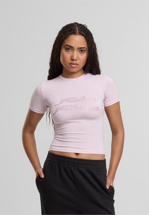 Rosa tettskjorte med kort erme, med en rhinestones grafisk tekst "Feeling Fabulous" foran. Materialet ser glatt og elastisk ut.