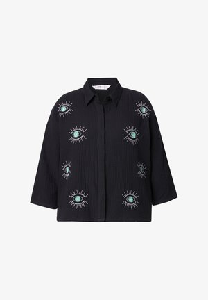Camicia nera con bottoni, maniche larghe, caratterizzata da occhi ricamati in verde e bianco. Tessuto strutturato con un design a vestibilità ampia.