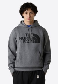 Grijze sweatshirt met capuchon, voorzien van een groot zwart logo op de voorkant. Zachte stof, kangoeroezak, geribbelde boorden en onderrand.