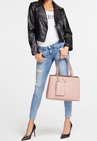 Svart läderbikerjacka, vitt linne, slitna ljusblå jeans och rosa tygväska i konstläder med detaljer. Svarta högklackade skor.