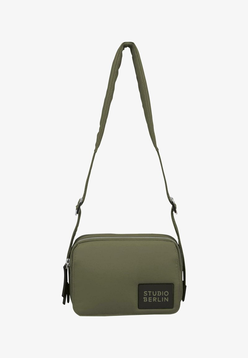 Oliwkowa torba na ramię wykonana z trwałego materiału, o prostokątnym kształcie, z zamkiem błyskawicznym i logo "STUDIO BERLIN" z przodu.