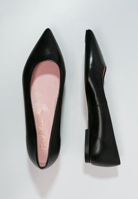 Bailarinas de cuero negro, con punta afilada, interior suave en color rosa y tacón bajo. Textura suave con un diseño minimalista.