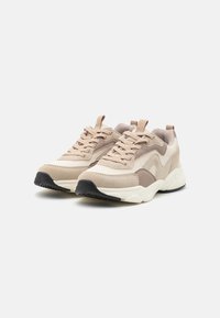 Beżowe sneakersy z siateczkowymi i zamszowymi panelami, z wiązaniem, wyściełanym kołnierzem oraz kontrastującą czarną gumową podeszwą.