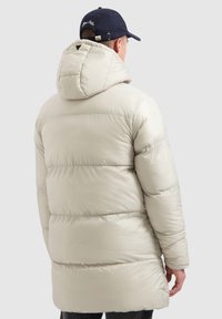 Lichtbeige gewatteerde jas met capuchon, doorgestikte textuur en lange mouwen, met een licht losse pasvorm en een detail met een achterventilatie.