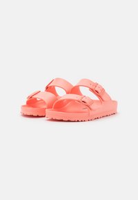 Sandalias moldeadas en color rosa con dos correas ajustables, textura suave y suela texturizada para mayor agarre. Hebillas en las correas para un ajuste seguro.