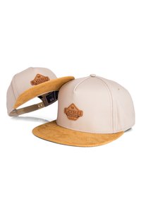 Cappellino da baseball beige con visiera in suede color sabbia, caratterizzato da una patch in pelle marrone e chiusura regolabile a snapback per una vestibilità perfetta.