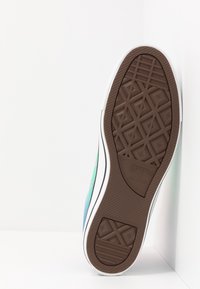 Semelle en caoutchouc marron avec un motif en diamant et un flanc blanc ; présente un design multicolore dans des tons de vert et de bleu.