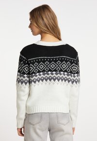Maglione lavorato a maglia in bianco, nero e grigio con un motivo geometrico sul giromanica. Presenta un collo rotondo, maniche lunghe e un orlo a coste. Texture morbida.