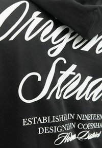 Schwarzer Hoodie mit großem, weißem Schriftsatz und detaillierter Druckgestaltung, einschließlich "Gegründet im 19" und "Entworfen in Kopenhagen."