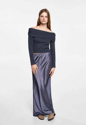 Haut gris foncé à épaules dénudées avec des manches longues, associé à une jupe fluide longue jusqu'au sol de couleur violette avec un motif subtil et une taille à cordon.