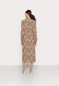 Vestido midi floral com fundo preto, apresentando flores laranjas, roxas e amarelas. Mangas longas, detalhes em botão e cintura ajustada.